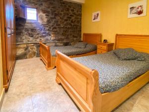 a bedroom with two beds and a stone wall at Alojamiento rural cerca de Bilbao in Basauri