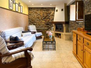 a living room with couches and a stone wall at Alojamiento rural cerca de Bilbao in Basauri