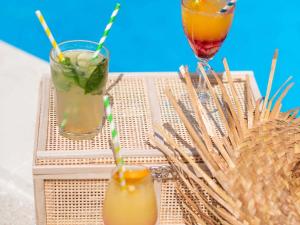 two cocktails sitting on a table with a drink at Hotel Novotel Evry Courcouronnes in Courcouronnes