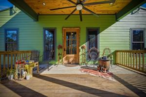 a front porch of a green house with a wooden ceiling at Raka Ranch Barndominium in Folsom