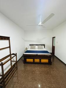 a bedroom with a bed and a ceiling fan at Ceylon Mist Villa in Narandanda