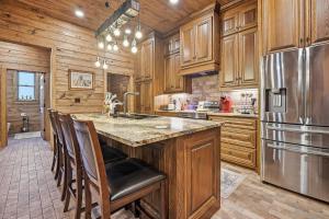 a kitchen with wooden cabinets and a kitchen island with a refrigerator at Raka Ranch Barndominium in Folsom