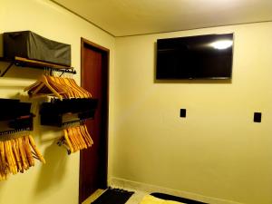 a room with a wall with a television and a door at Tiny House, Refúgio Aconchegante em Mucugê in Mucugê