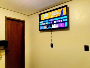 a flat screen tv hanging on a wall at Tiny House, Refúgio Aconchegante em Mucugê in Mucugê