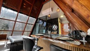 eine Küche mit Theke, einigen Stühlen und Fenstern in der Unterkunft Cabanas do vale in Itaquá