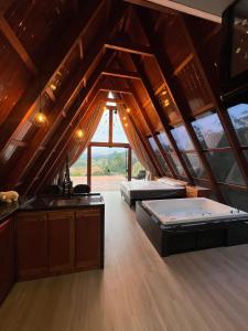 ein Dachzimmer mit zwei Betten und einer Küche in der Unterkunft Cabanas do vale in Itaquá