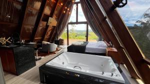 eine große Badewanne in einem Zimmer mit einem Schlafzimmer in der Unterkunft Cabanas do vale in Itaquá + 33 Fotos