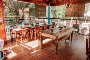 a dining room with wooden tables and chairs at Pousada Vilarejo de Minas in Itapeva