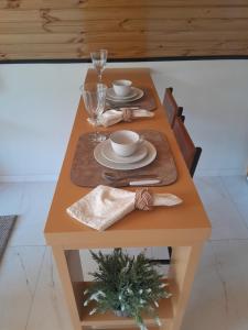 a table with two plates and a cup and a glass at Sombra do baú - Aurora in Timbe do Sul +5 photos