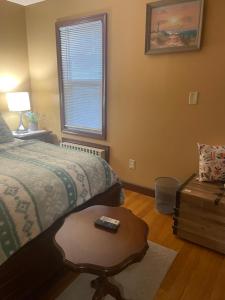 a bedroom with a bed and a table and a window at Private Unit with own Entrance To Share in South Ozone Park