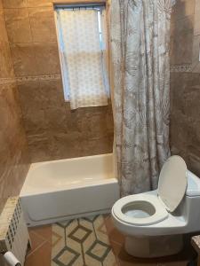 a bathroom with a toilet and a bath tub at Private Unit with own Entrance To Share in South Ozone Park +36 photos