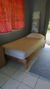 a bed sitting in a room with a window at Chez Hina no Pacifica in Bora Bora