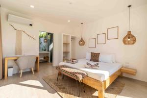 a bedroom with a bed and a desk and a chair at Villa Nindot - Private pool villas - Adults only in Siquijor