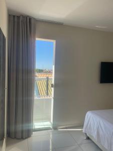 a bedroom with a sliding glass door to a balcony at Apartamento Novo e ventilado in Petrolina
