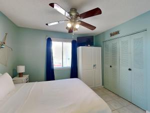 a bedroom with a white bed and a ceiling fan at Island Home 102 in Destin
