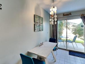 a dining room with a wooden table and blue chairs at Island Home 102 in Destin