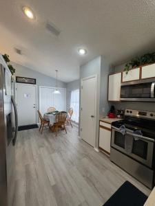 a kitchen and dining room with a table and refrigerator at Pool Home 15 Minutes From Disney in Davenport
