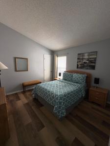 a bedroom with a bed with a blue comforter and a window at Pool Home 15 Minutes From Disney in Davenport +46 photos
