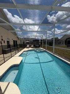 a large swimming pool with a large roof at Pool Home 15 Minutes From Disney in Davenport