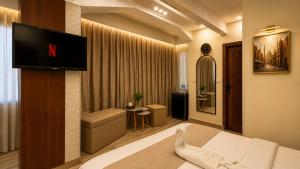 a hotel room with a tv and a bedroom at Queen Cleopatra Boutique Hotel in Cairo