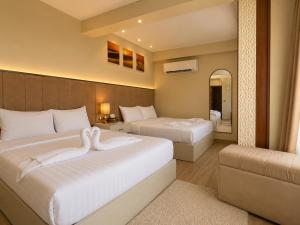 a hotel room with two beds and a mirror at Queen Cleopatra Boutique Hotel in Cairo