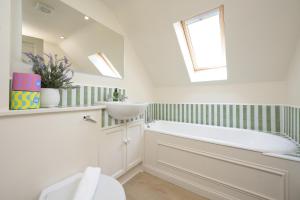 a bathroom with a tub and a sink and a mirror at Cardross Holiday Cottages in Arnprior +198 photos