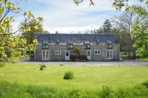 an old stone house with a large yard at Cardross Holiday Cottages in Arnprior