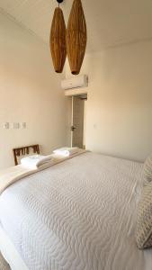 a large white bed in a room with two lights at Vila Anambé in Uruçuca +28 photos