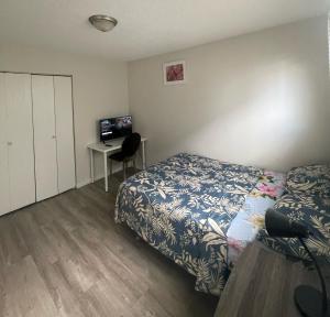 a bedroom with a bed and a desk with a television at Ron's Place in Saskatoon +2 photos