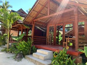 a wooden house with stairs in front of it at Camp Olli Beach Villas in Dapa