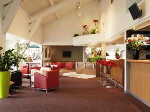 a lobby with red chairs and a waiting room at ibis Nemours in Nemours