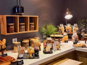 a counter with many jars of food on it at ibis Nîmes Ouest - A9 in Nîmes +90 photos