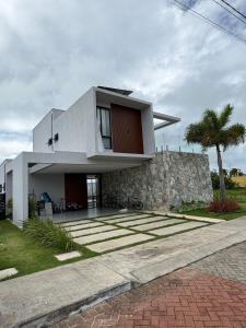 a modern house with a stone wall at Condomínio Bosque da Praia, casa 193 Jacumã RN in Jacumã