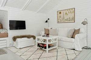a white living room with a white couch and a table at Experience Nature's Embrace And Peace in Græsted