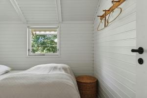 a bedroom with white walls and a window at Experience Nature's Embrace And Peace in Græsted