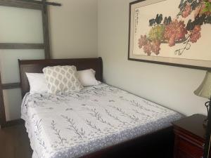 a bed in a bedroom with a picture on the wall at Spacious 3 bedrooms 1 bath Jacuzzi BBQ SINGLE HOUSE in Agoura Hills
