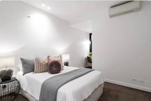 a bedroom with a bed with a cat sitting on it at City Vibe on Dorcas Southbank in Melbourne