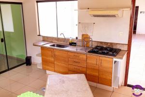 a kitchen with a sink and a stove top oven at Casa Shanti - conforto e tranquilidade. in Dourados