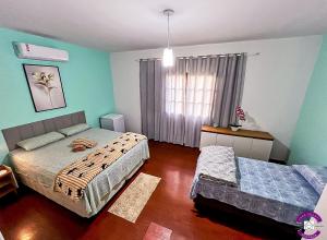 a bedroom with two beds and a window at Casa Shanti - conforto e tranquilidade. in Dourados