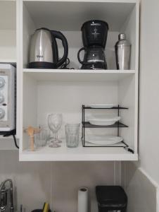 a kitchen shelf with dishes and utensils on it at Casa Almendra in Búzios +11 photos