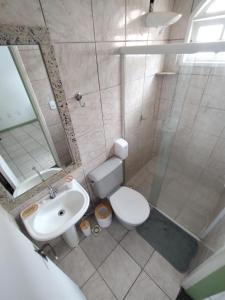 a bathroom with a toilet and a sink and a mirror at Casa Almendra in Búzios