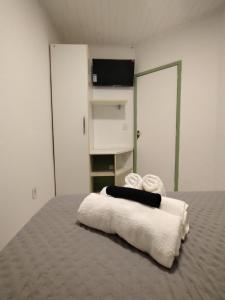 a room with a bed with towels on it at Casa Almendra in Búzios
