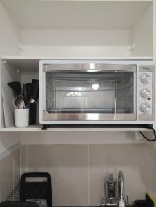 a microwave oven on a shelf in a kitchen at Casa Almendra in Búzios