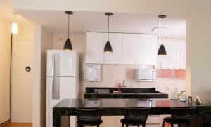 a kitchen with white cabinets and a black counter top at Caldas novas - Parque das Água Quentes - Conforto e lazer completo -Edi Locações in Caldas Novas