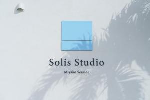 a sign on a wall with a shadow of a plant at Solis Studio Miyako SeaSide in Miyako-jima