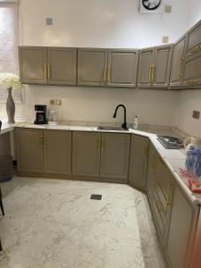a kitchen with green cabinets and a sink at شالية الفهد in As Sayl al Kabīr