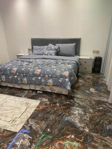 a bedroom with a bed and a marble floor at شالية الفهد in As Sayl al Kabīr