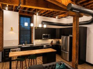 a large kitchen with a counter and a refrigerator at Brick & Bed Riverfront Lofts, T 303 in Saint Louis