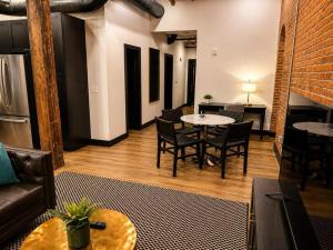 a living room with a couch and tables and chairs at Brick & Bed Riverfront Lofts, T 303 in Saint Louis +7 photos