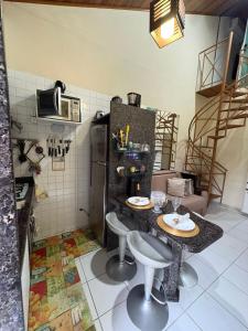a kitchen with a table and a refrigerator at Flat Monte Castelo Gravatá - Pe in Gravatá